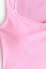 Top deportivo cropped de color rosado con escote corazón y soutien incorporado, confeccionado en tejido funcional con tecnología SculptMove™ y DryMove™.