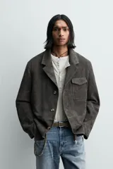 Blazer relaxed fit de piel con acabado ante, color gris oscuro. Cuello con solapas de muesca, manga larga, bolsillo de plastrón con solapa en el pecho y dos bolsillos de plastrón en la cadera. Cierre frontal de botonadura con botones claros.