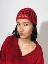 Gorro tipo casquete rojo de crochet con diseño calado.