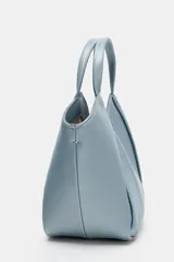 Bolso mini shopper de cuero sintético en color marrón, con diseño estructurado y costuras decorativas contrastantes. Cuenta con doble asa de mano y cierre magnético.