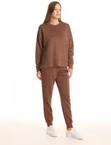 Buzo deportivo de cuello redondo, con hombros caídos y mangas largas con puños. Presenta costuras decorativas tipo pespunte en la parte frontal y en las mangas, con un diseño de ruedo recto y tajos laterales.