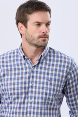 Camisa de lino y algodón con diseño a cuadros en tonos de azul, beige y blanco, de manga larga, cuello abotonado y cierre frontal con botones.