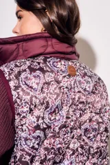 Chaleco bordeaux con interior estampado floral, de corte al cuerpo y cierre frontal con cremallera.