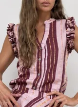 Blusa sin mangas a rayas en tonos beige y marrón oscuro, con escote en V, cuello mao y botonadura frontal parcial. Cuenta con delicados volados fruncidos en los hombros.