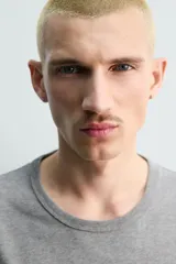 Camiseta de manga larga color gris jaspeado, corte regular fit y cuello redondo con acabado en rib.