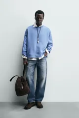 Sudadera azul con corte relaxed fit, cuello redondo y mangas largas con puños de rib, confeccionada en tejido con mezcla de algodón y acabado afelpado en el interior.