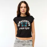 Camiseta corta negra con estampado frontal de flor azul y texto "Demogorgon Fan Club" en blanco.
