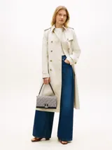 Cartera bandolera Tommy Hilfiger de diseño estructurado, confeccionada en jacquard con monogramas TH en tonos azul marino y beige, combinada con detalles en cuero sintético negro. Cuenta con solapa frontal, cierre metálico con logo, asa superior y correa extraíble.
