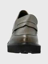 Mocasín de cuero color verde oliva con textura granulada, diseño clásico con antifaz y suela track de plataforma alta en color negro.
