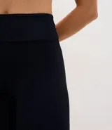 Pantalón deportivo tipo legging flare de tiro alto, confeccionado en microfibra con abertura lateral en el ruedo.