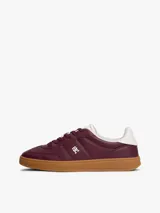 Zapatillas de corte bajo confeccionadas en piel napa brillante color bordó, con suela de goma color caramelo. Presentan insignia metálica del monograma TH en el lateral y detalle en blanco en el talón.