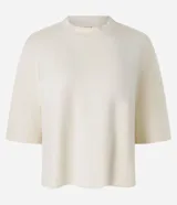 Remera de modal color crudo, con diseño minimalista, calce amplio, cuello redondo y mangas cortas amplias con hombros caídos.