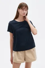 Blusa de viscosa color azul marino, con cuello a la base, mangas cortas y detalle de plisado cruzado en la parte superior delantera. Presenta un corte holgado.