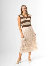 Maxi falda color beige con flecos escalonados y diseño de capas, confeccionada en tela elastizada con cintura elástica.