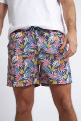 Short de baño con cintura elástica y cordón ajustable, confeccionado en tela ligera de secado rápido. Presenta un estampado botánico integral en tonos amarillos, blancos y azules, con dos bolsillos delanteros y uno posterior.