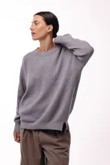 Sweater de punto con cuello redondo, mangas largas con hombros caídos y silueta relajada.