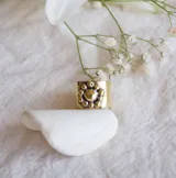 Anillo de bronce con forma cuadrada y diseño de margarita con centro dorado y pétalos plateados.