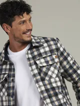 Sobrecamisa a cuadros azul, verde y blanco, con cuello camisero, cierre frontal con botones, dos bolsillos de parche con botón en el pecho y puños abotonados.