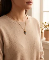 Collar de bronce dorado con cadena de eslabones finos y dije colgante en forma de zapatito decorado con esmalte negro, turquesa, blanco y detalles brillantes.