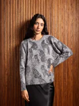 Buzo de punto gris con estampado de tigres en color negro, cuello redondo y mangas largas con puños acanalados.