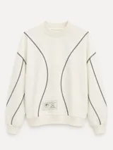 Buzo blanco de manga larga con diseño holgado, cuello redondo y costuras externas visibles en contraste. Cuenta con una etiqueta decorativa en el frente inferior.