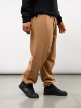 Pantalón de felpa color crema, con corte relajado, costuras verticales en la parte delantera y etiqueta con el logo de Umbro.