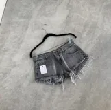 Short de denim gris oscuro con efecto acid wash, tiro medio y dobladillo deshilachado con flecos.