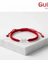 Pulsera de hilo rojo tejida en macramé con dijes de plata 925 en forma de niño y niña, con terminaciones ajustables decoradas con esferas de plata.