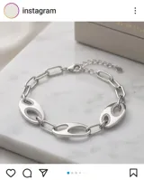Pulsera de plata con eslabones ovalados y detalles de circonias engarzadas.
