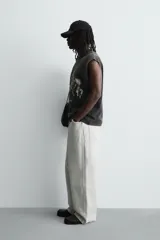 Camiseta sin mangas (tank top) de algodón con efecto lavado oscuro, corte cropped y cuello redondo. Presenta un estampado frontal en blanco con varios caballos en estilo gótico y texto en la parte inferior.