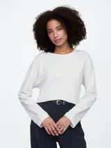 Remera de manga larga con cuello redondo, confeccionada en tejido de punto con textura jaspeada y corte holgado.