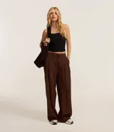Pantalón wide leg de sastrería color marrón, con cintura elástica, lazo ajustable y pliegues delanteros.