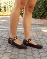 Chatitas de gamuza color chocolate con tira ajustable al tobillo, decorada con remaches metálicos y hebilla plateada.