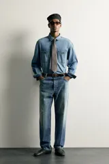 Camisa relaxed fit confeccionada en denim ligero de algodón, con cuello solapa, manga larga con puño abotonado, dos bolsillos de parche en el pecho con solapa y cierre frontal de botones. Presenta un efecto de lavado desgastado.