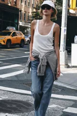 Chaqueta de manga larga con estampado de cuadros vichy en tonos marrón y blanco, cuello camisero, cierre frontal con botones y bajo ajustable con cordón.