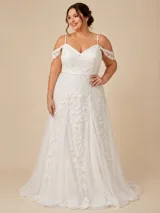 Vestido largo de novia en tul con bordados florales en hilo. Presenta escote en V, breteles finos y mangas caídas con detalle de encaje. La falda tiene un diseño fluido con godets que aportan volumen.