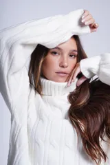 Sweater tejido color crudo con cuello alto y diseño de ochos.