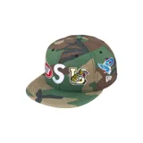 Gorra tipo snapback de Supreme con diseño de camuflaje woodland. Presenta bordados frontales con letras y un tigre, además de un logo lateral de un águila y el logo de New Era.