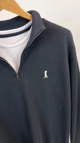 Buzo de algodón de punto color negro con medio cierre.