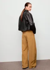 Jeans de tiro bajo y diseño wide leg, confeccionados en tejido de pana color tostado, con cinco bolsillos, trabillas para cinto y cierre frontal con botón y cremallera.