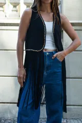 Chaleco de estilo boho confeccionado en cuero sintético color marrón, con flecos largos en el ruedo y detalle de tachas metálicas a lo largo de los bordes frontales.