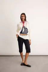 Sweater de punto color marfil con diseño de velero en la parte frontal, cuello con capucha y cordón rojo de ajuste.