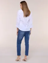 Camisa de poplín de algodón blanca, de silueta semi entallada con cuello camisero, escote en V, abotonadura frontal con botones joya, mangas tres cuartos con puños anchos y laterales elastizados al tono.
