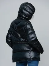Campera puffer de Calvin Klein con acabado brillante, diseño acolchado con costuras en V, cierre frontal con cremallera, capucha integrada y bolsillos laterales con cierre.