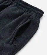 Pantalón deportivo de corte jogger, color negro, con cintura elástica ajustable mediante cordón, bolsillos laterales y puños acanalados en los tobillos. Confeccionado en tejido de algodón con interior felpudo.