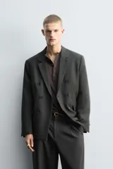 Blazer de corte relajado confeccionada en lana de origen italiano, con diseño de doble botonadura cruzada. Presenta cuello con solapas de muesca, manga larga con botones en puños, bolsillos con solapa en la cadera y abertura central en la espalda. Incluye forro interior a contraste.