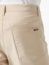 Pantalón de vestir color beige, de corte recto y tiro medio. Confeccionado en poliéster.