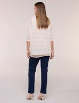 Buzo de tejido calado a rayas horizontales en tonos beige y blanco, de corte holgado, mangas cortas y escote redondo. Incluye musculosa interna básica en color beige.