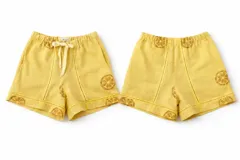 Short de tiro medio con cintura elastizada, confeccionado en mezcla de lino y algodón, color amarillo con estampado artesanal de rodajas de limón en tono marrón. Presenta detalles de pespuntes y entredos a tono.