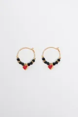 Caravanas de aro doradas con cuentas de cristal facetadas en color negro y un dije central en forma de corazón esmaltado en color rojo.